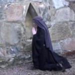 Nunna utomhus i bön